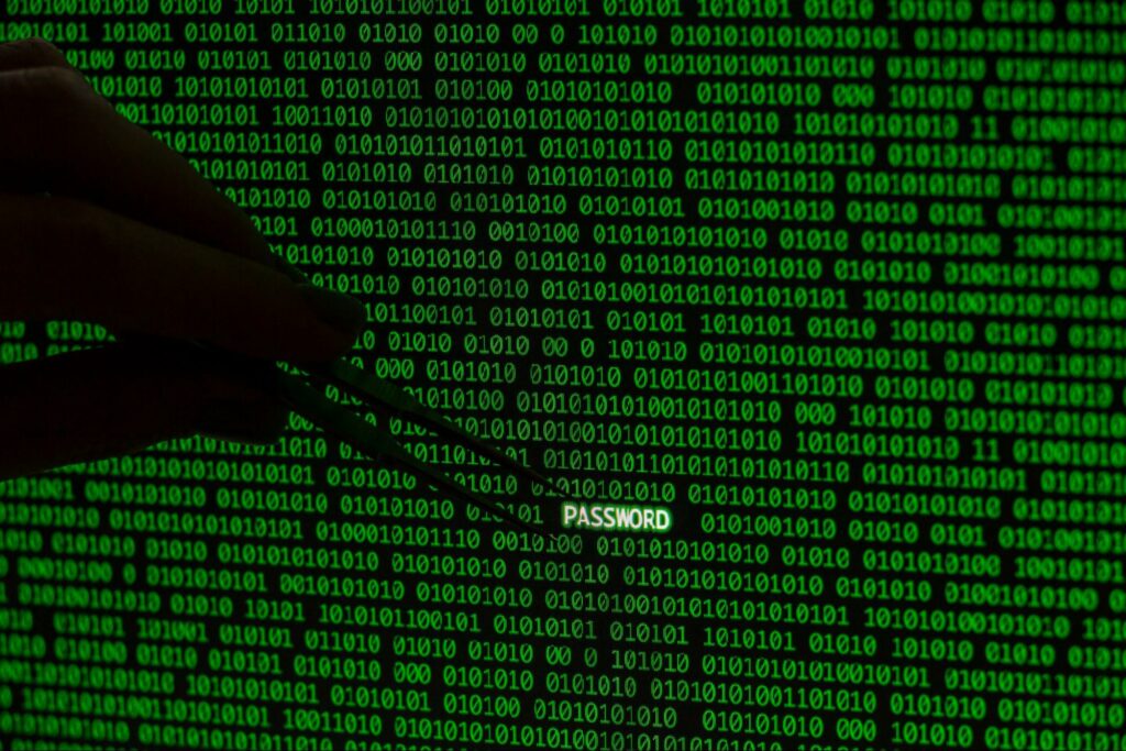 An image featuring a hand holding tweezers over a password, intertwined with binary code, highlighting the vigilant protection of digital assets.