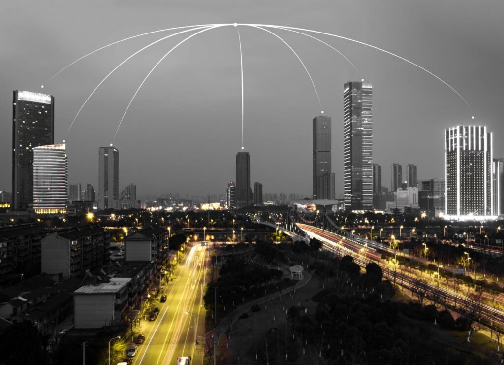 A portrayal of illuminated large buildings with dome lights, metaphorically representing the safeguarding of vital infrastructure in the digital landscape.