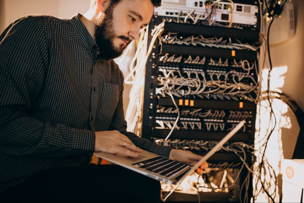 Young IT service man expertly repairing a computer, illustrating technical proficiency, merged with the concept of Hardware-based Cybersecurity for a holistic approach to digital maintenance and protection.